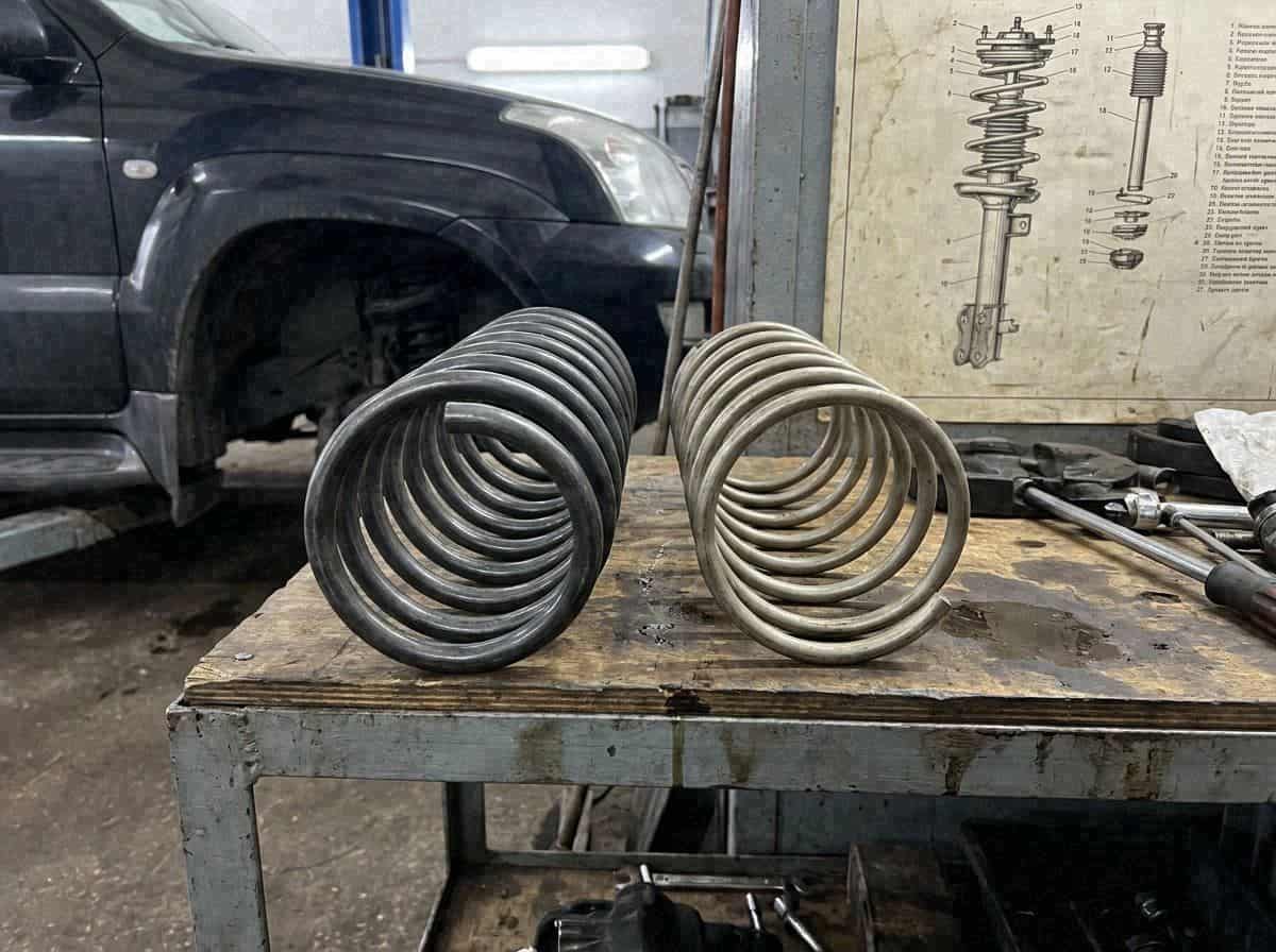 Две витые пружины подвески на верстаке в мастерской — Custom's Tuning, Тюмень